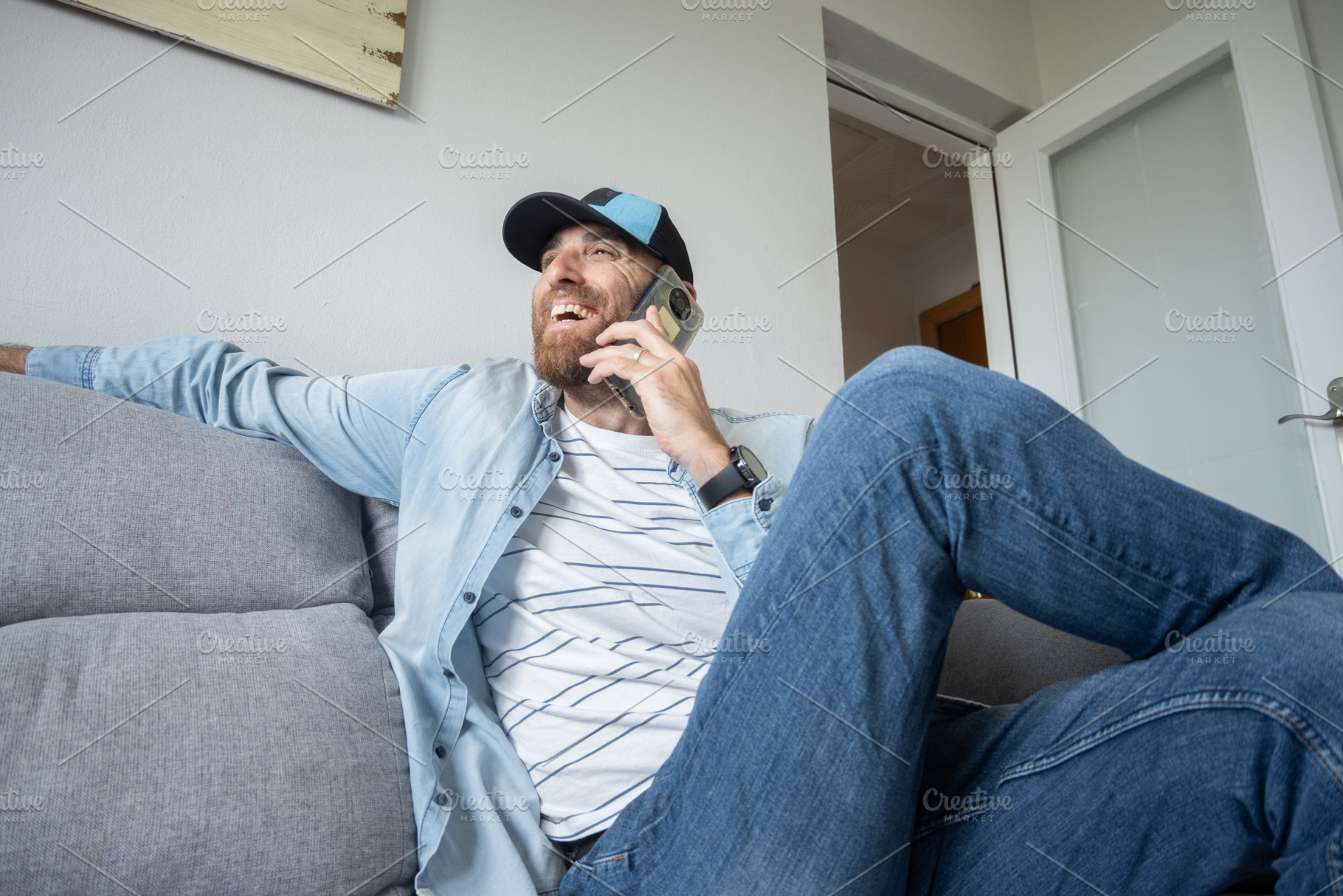 Man talking on smartphone sitting on sofa at home, casual lifestyle, a Person Photo by etorres69