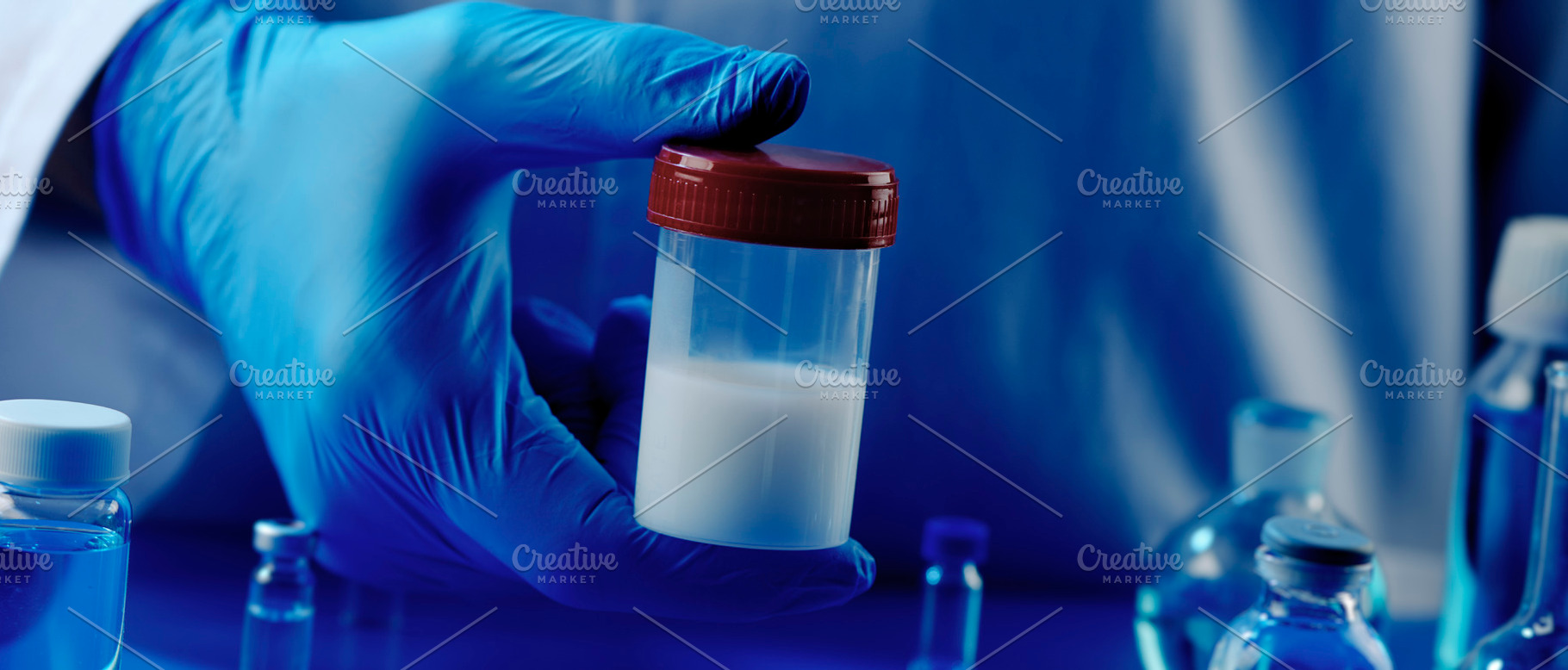 man holding a container with semen, banner, a Photo by Nito