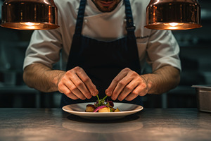 Chef carefully garnishes a dish, a Food & Drink Photo by professorinc