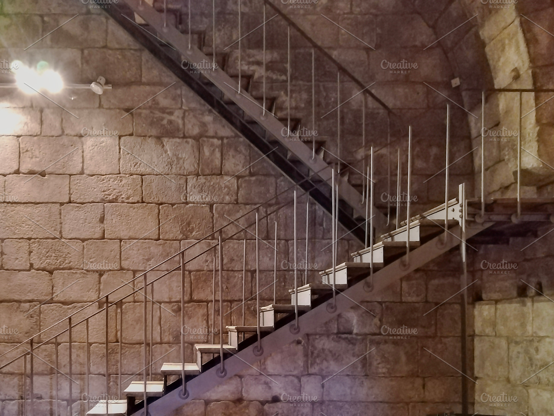 Modern stairs crossing medieval stone interior, an Architecture Photo by DanFLCreativo