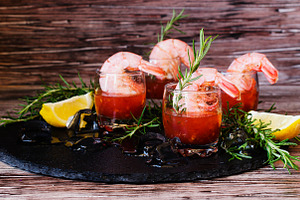 Appetizer of shrimp cocktail with rosemary and sauce selective focus