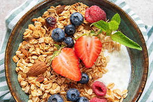Granola bowl with yogurt, berries, and mint, a Food & Drink Photo by Olena Rudo