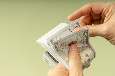 Hands counting US dollar bills, symbolizing finance, payment, ba