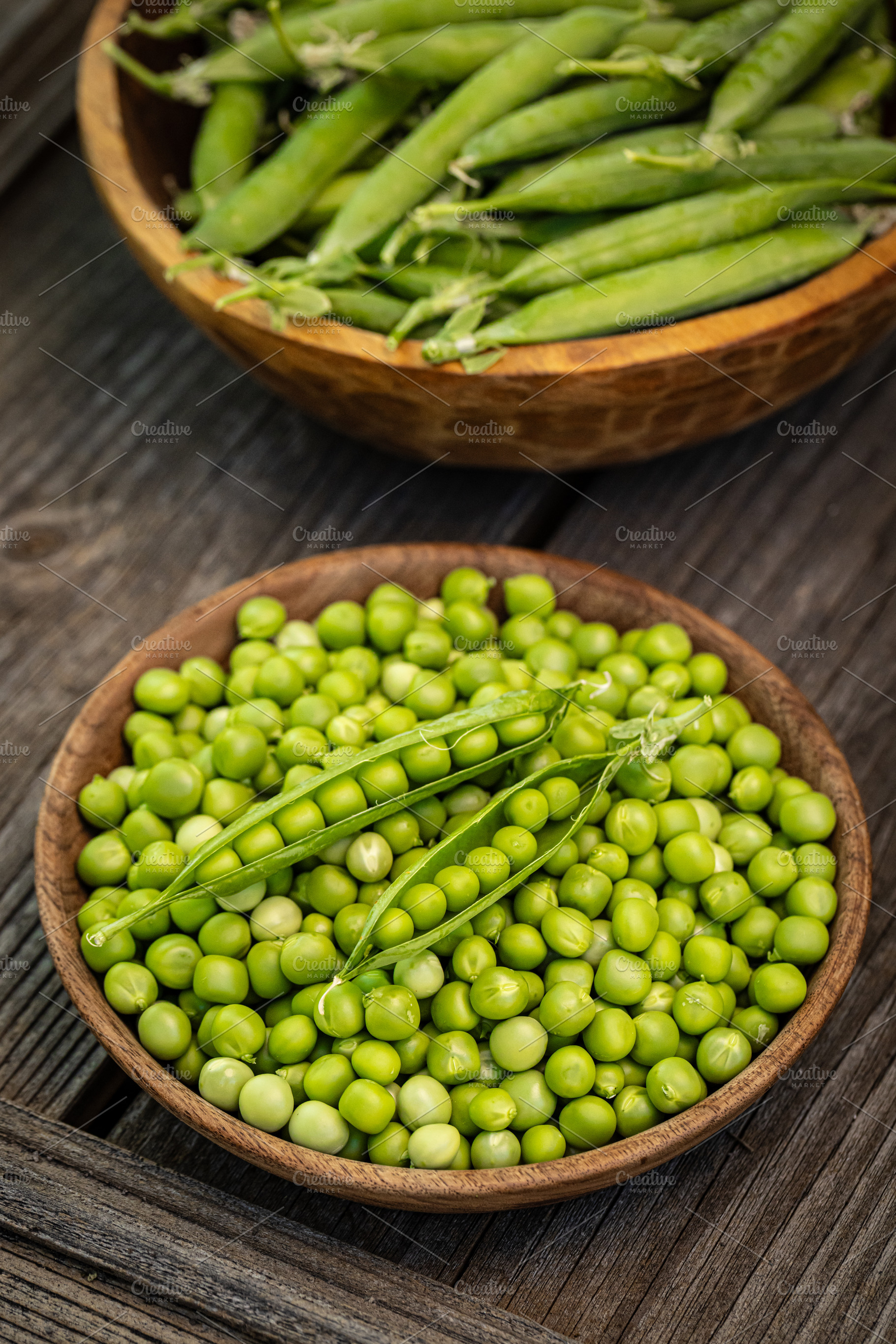 Fresh green peas in wooden bowls, a Photo by Grafvision photography
