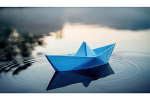 A blue paper boat floating on calm, a Nature Photo by Igor Tichonow
