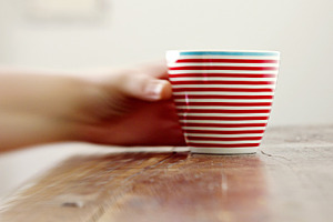 Blurry hand grabbing a striped mug