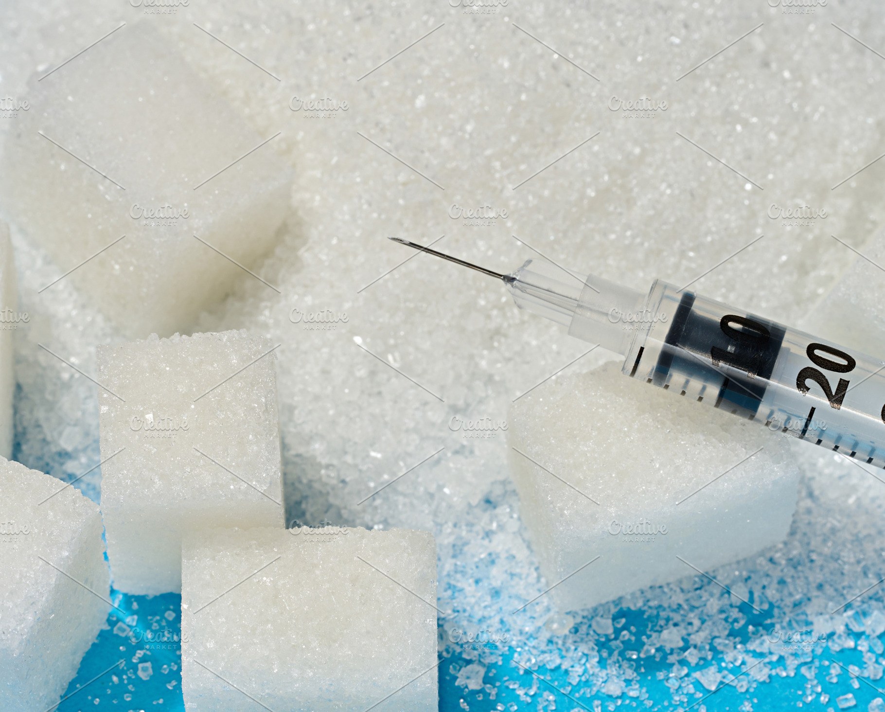 A medical syringe lying on cubes of refined sugar and scattered, a Food & Drink Photo by ndanko