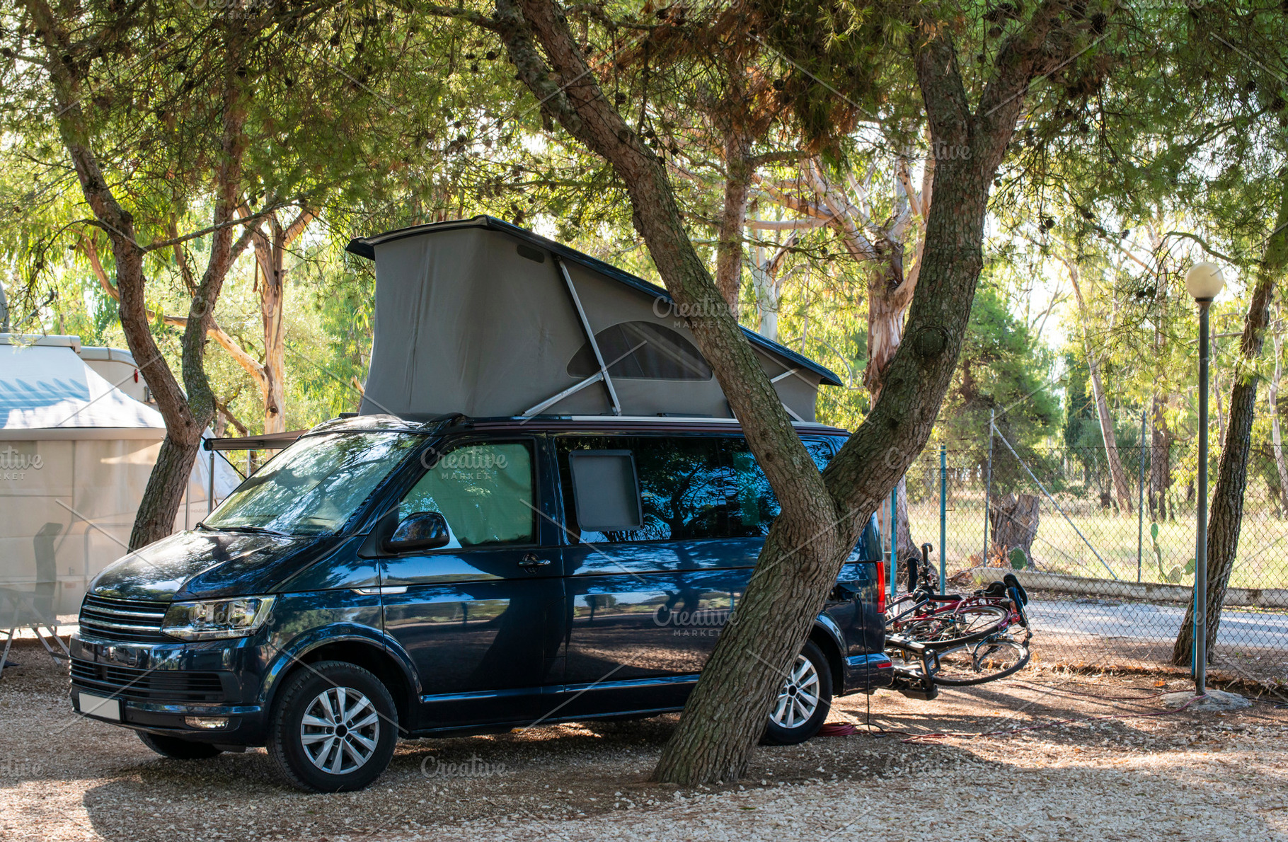 Dark blue camper caravan on camping containing campsite, caravan, and, a Holiday Photo by Deyan Georgiev
