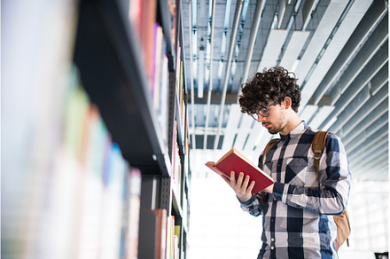 Male student in library, looking for, a School & Education Photo by HalfPoint