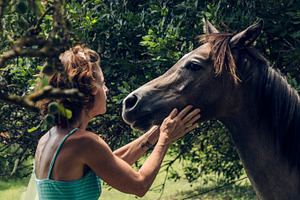 Woman petting a young horse