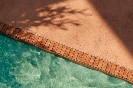 Top view of orange poolside in luxury hotel villa with sunlight