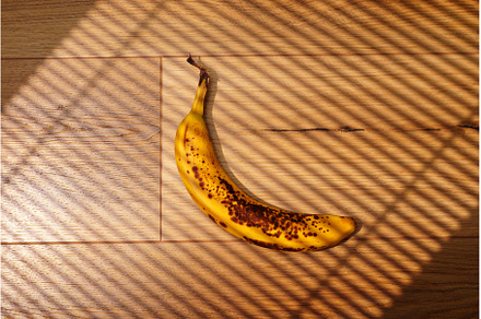 A bright yellow banana with brown