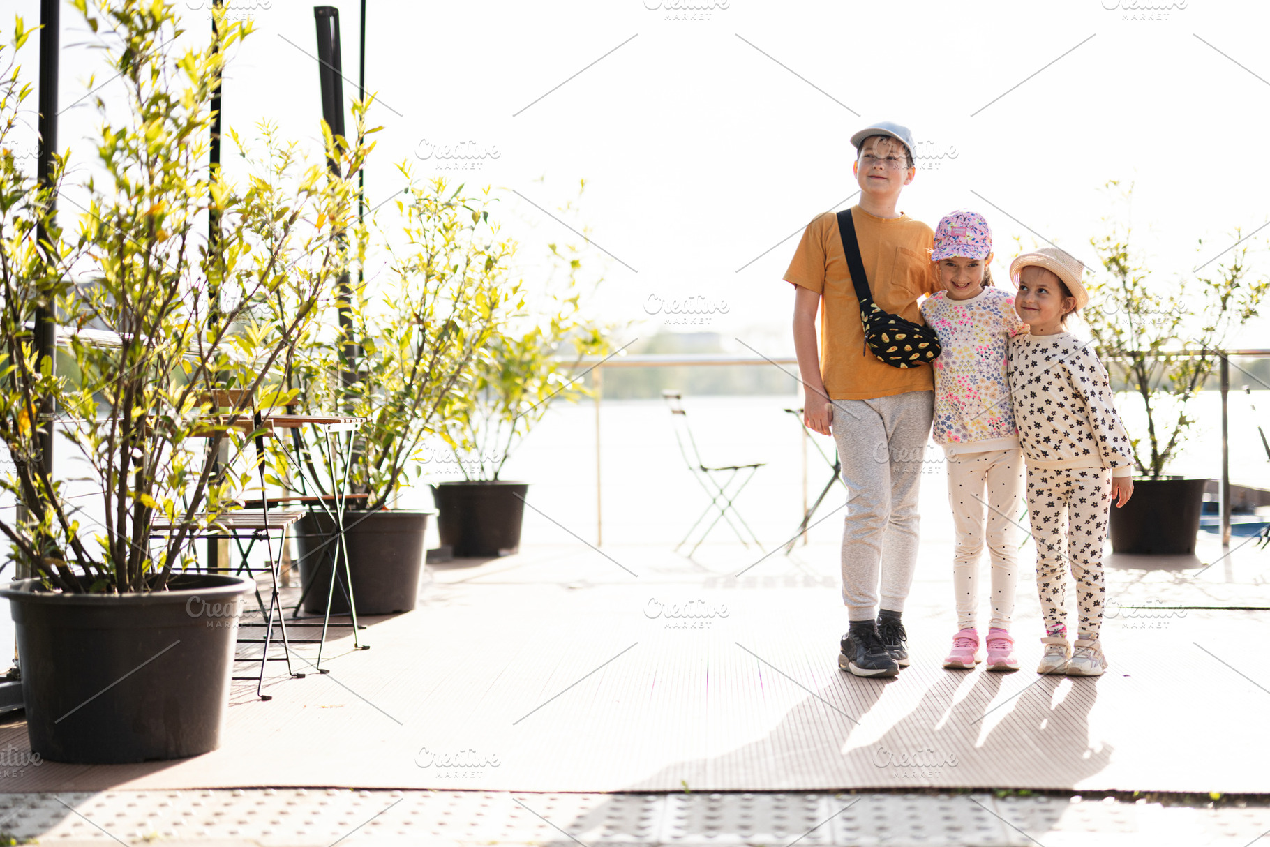 Children enjoying a sunny outdoor day near a scenic garden, a Person Photo by AS photostudio