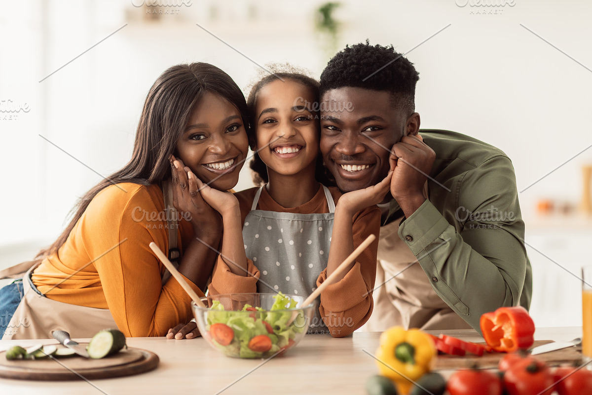 African American Family Of Three Making Salad Cooking Together Indoor, a Photo by Prostock-Studio (Photo 1 of 3)