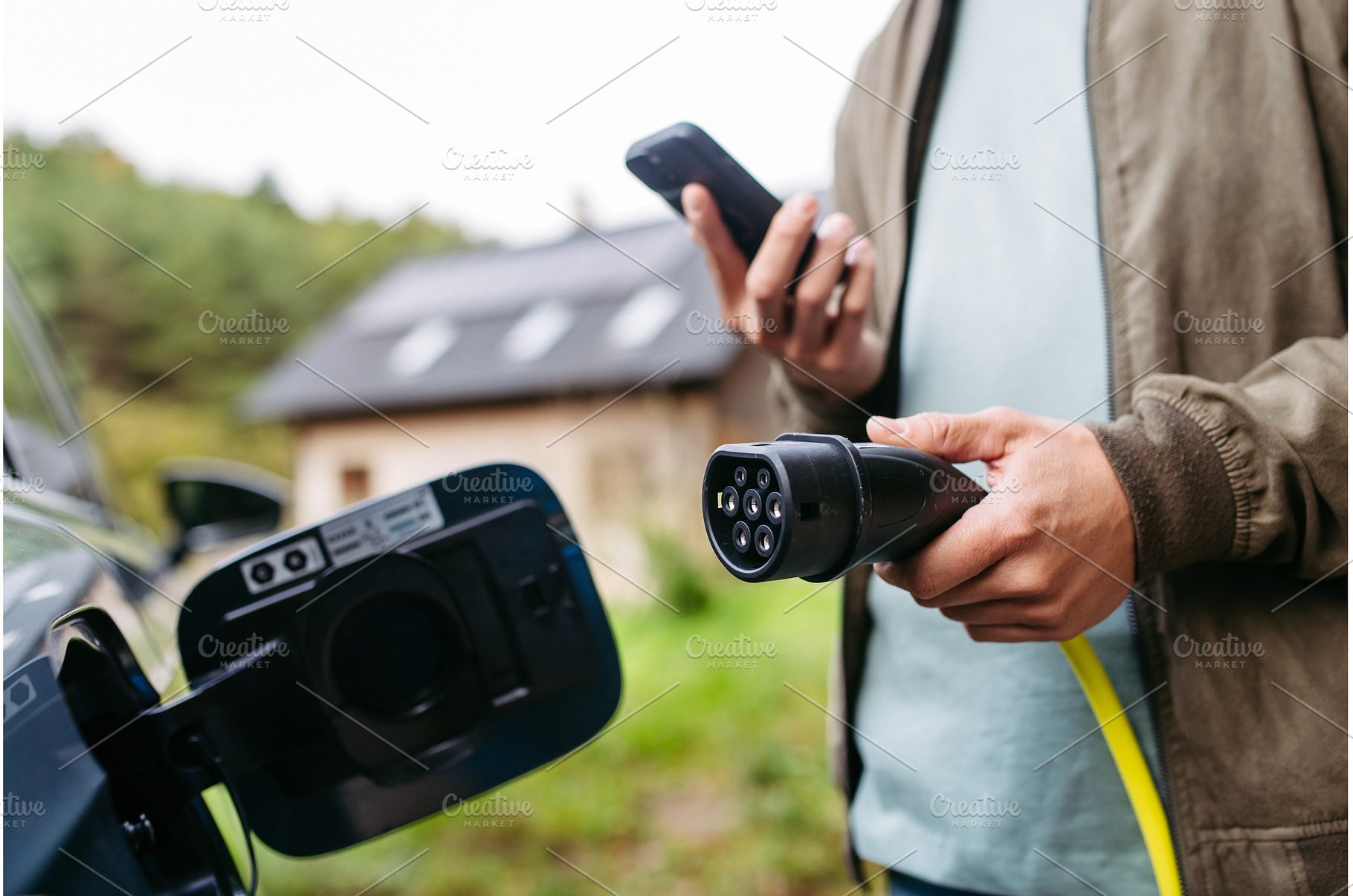 Man charging electric car in front, a Transportation Photo by HalfPoint