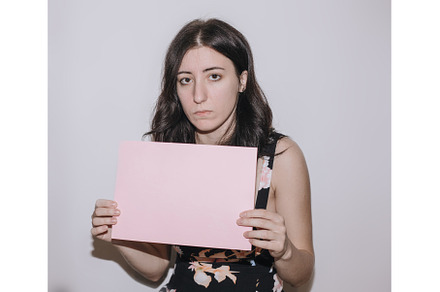 Sad young woman holding a blank, a Person Photo by zheckasmk