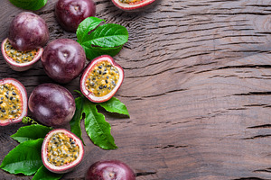 Dark purple passion fruits and it's half with seedly interior on, a Food & Drink Photo by Volff