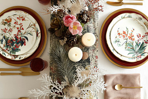 Festive holiday dinner table setting with elegant floral plates, golden cutlery, a Food & Drink Photo by Studio ANNA