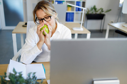 Office worker sniffing green apple, a Food & Drink Photo by borodai94