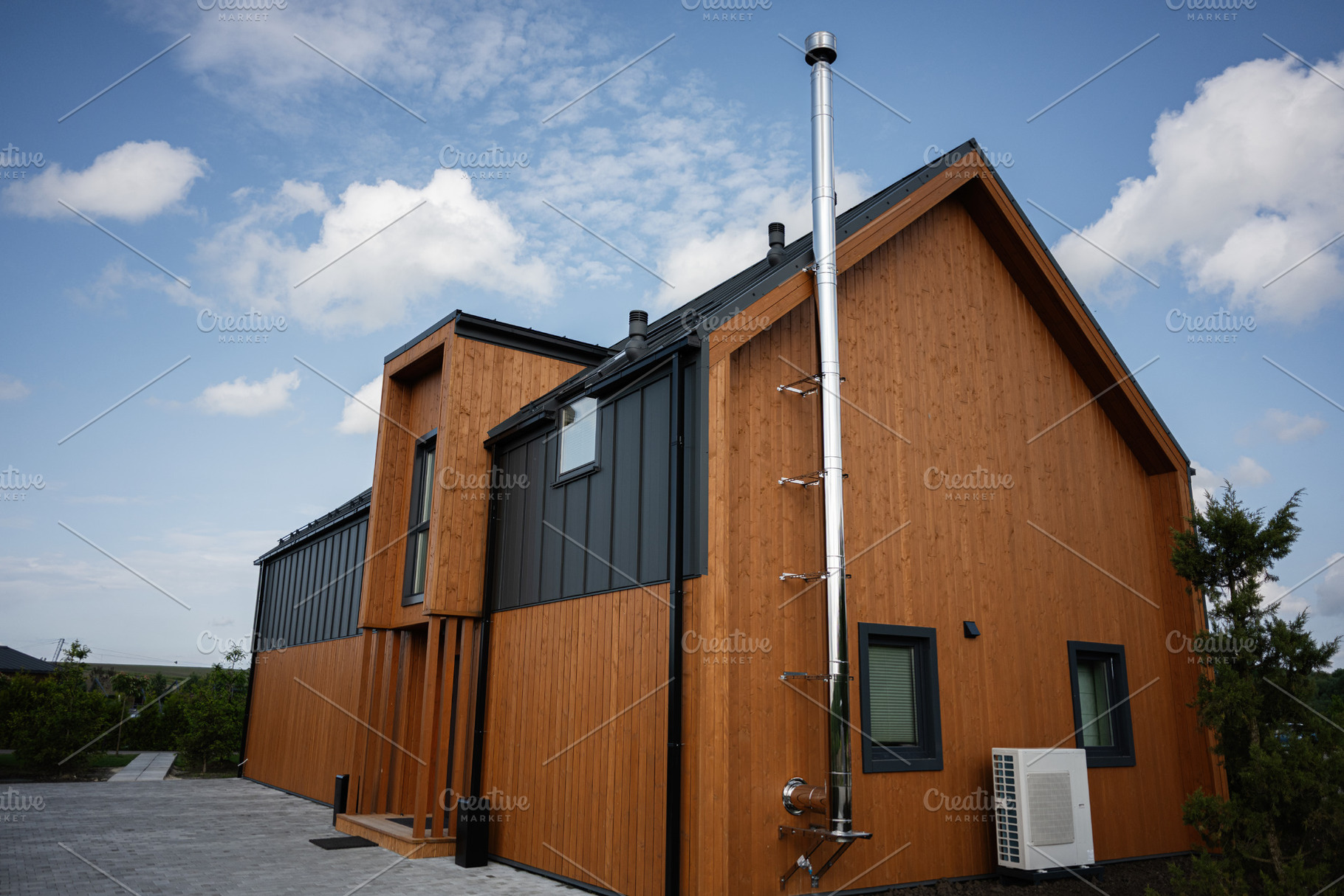 Modern wooden house exterior with metal accents under a blue sky, a Photo by AS photostudio