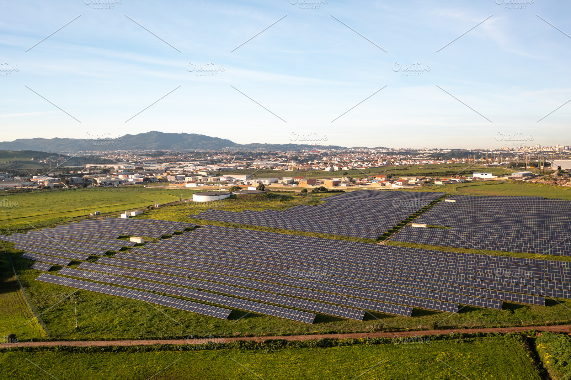 Solar energy farm captures sunlight in rural setting with mountains in the back, a Photo by andreonegin market