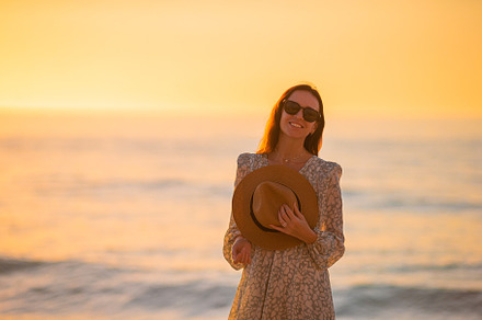 Young beautiful woman at straw hat on the beach at sunset, a Person Photo by travnikovstudio