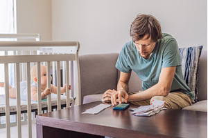 Father sitting on sofa calculating