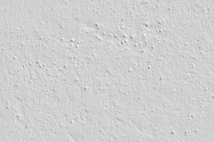 White plaster wall with lumpy stucco