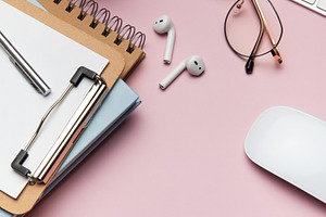 Workspace organizing accessories on pink table with plant and ke, a Business Photo by Olena Rudo