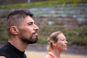 Active couple standing outdoors, woman in foreground looking ahead with focus, a Sports & Recreation Photo by etorres69