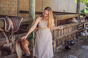 Woman gently strokes a pony during a, a Person Photo by Elizaveta Galitskaya