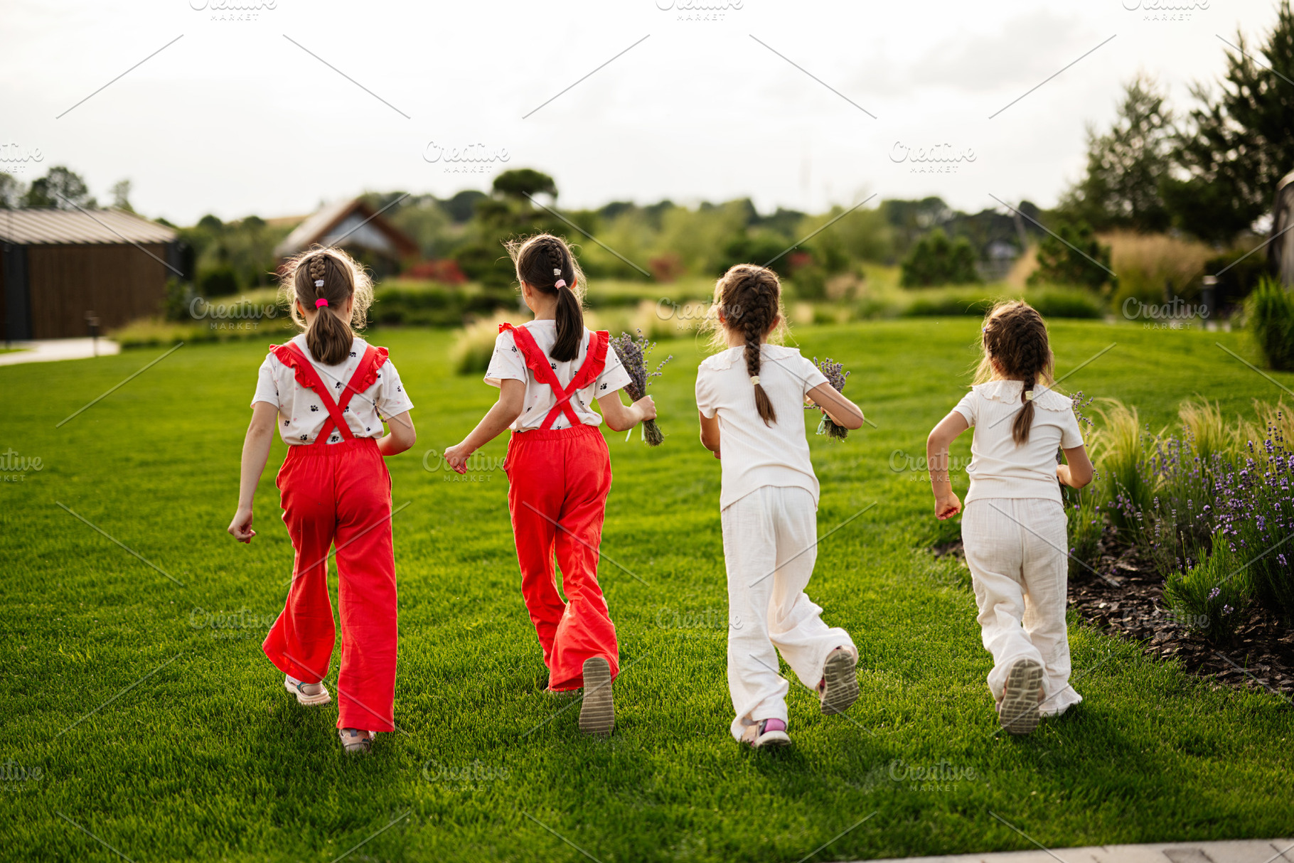 Children running on lush green grass in a peaceful countryside setting, a Photo by AS photostudio