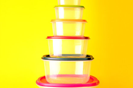 Transparent plastic containers with colorful lids stacked in a p