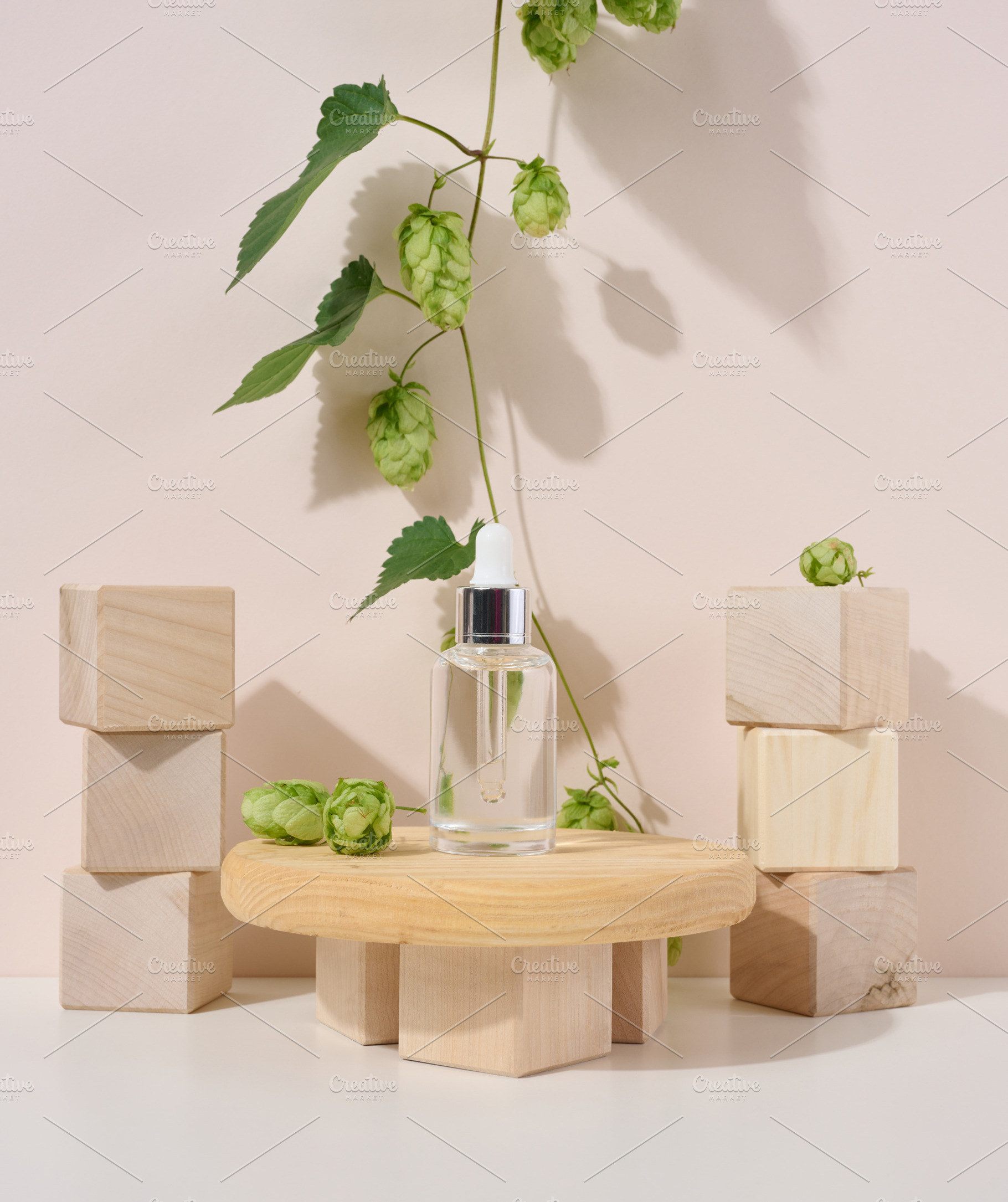 A white glass bottle with a pipette on a beige background. Conta, a Beauty & Fashion Photo by ndanko
