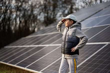 Boy child on the background of solar panels.  Eco energy., a Technology Photo by AS photostudio