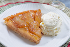 Slice of apple tarte tatin with scoop of whipped cream, french upside down cake, a Food & Drink Photo by iuliia_n