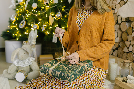 Woman opening her new year or christmas gift box while sitting at home. Concept, a Holiday Photo by Anikona