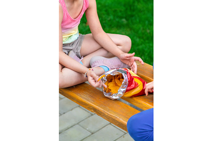 The child eats chips in the park, a Person Photo by yanadjana