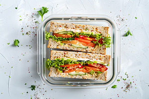 School lunch box with tasty sandwich on the table, a Food & Drink Photo by AlyaAnd