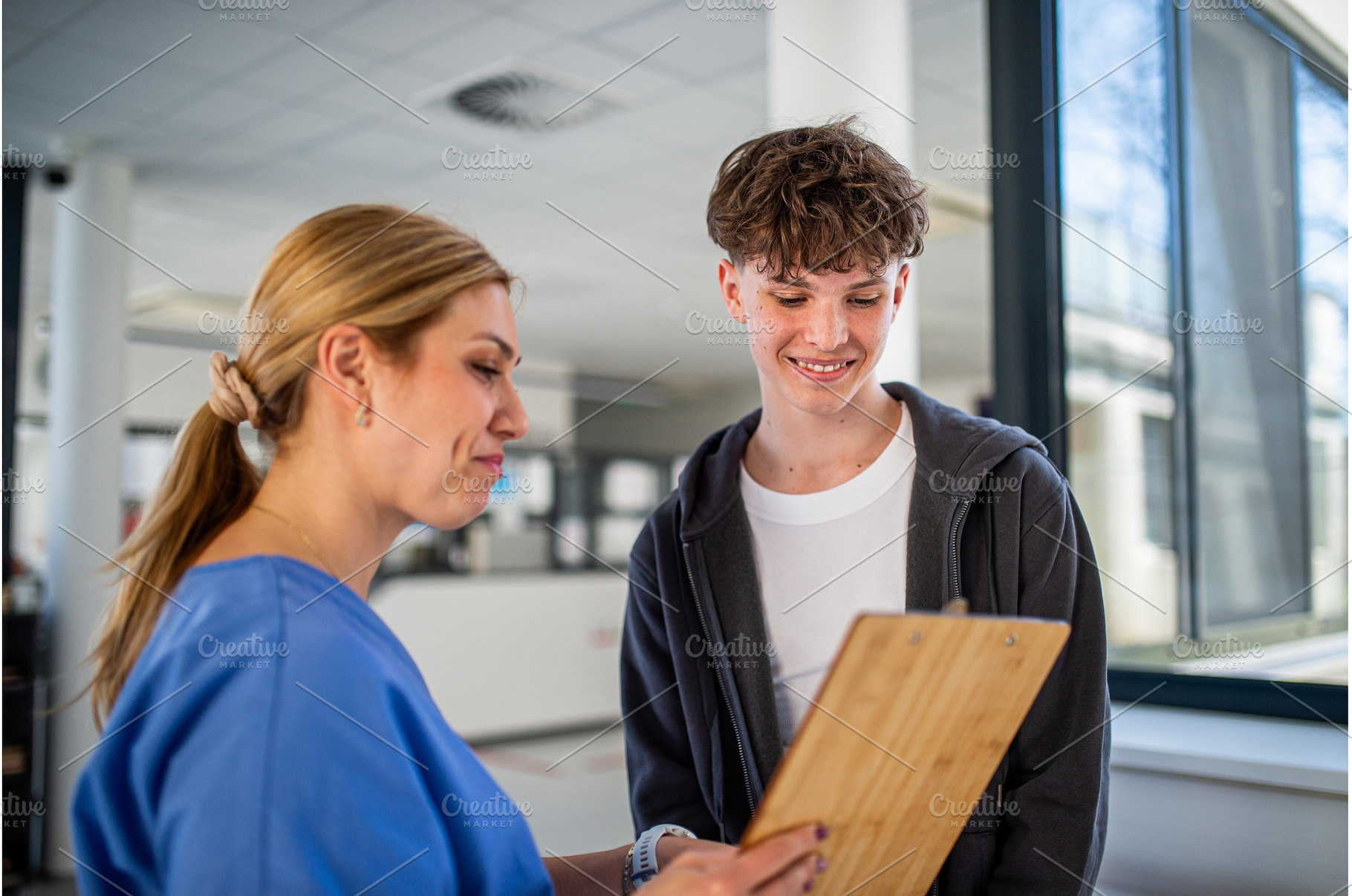 Doctor talking with teenage boy in, a Person Photo by HalfPoint