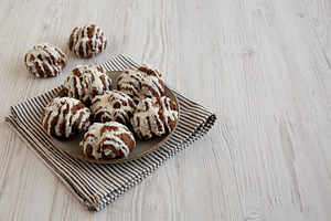 Homemade Profiteroles with Coconut Cream on a Plate, side view., a Food & Drink Photo by LiudmylaChuhunova
