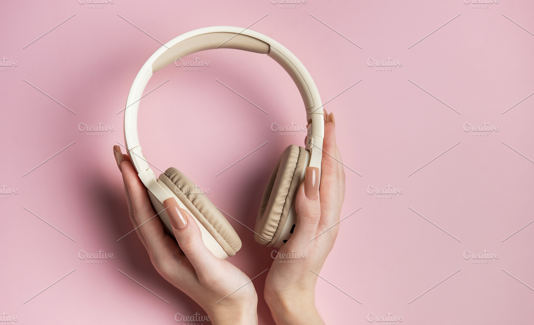 Woman holding wireless headphones on pink background, a Technology Photo by Olena Rudo