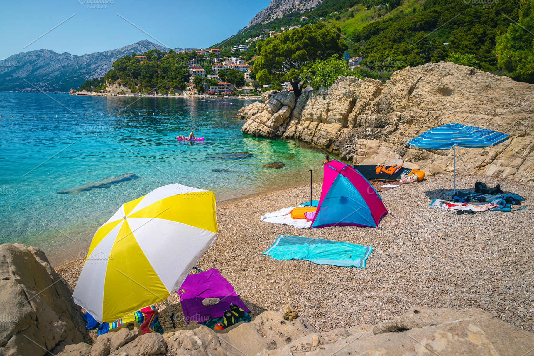Amazing gravelly beach with parasols, a Holiday Photo by Alpine Dreams