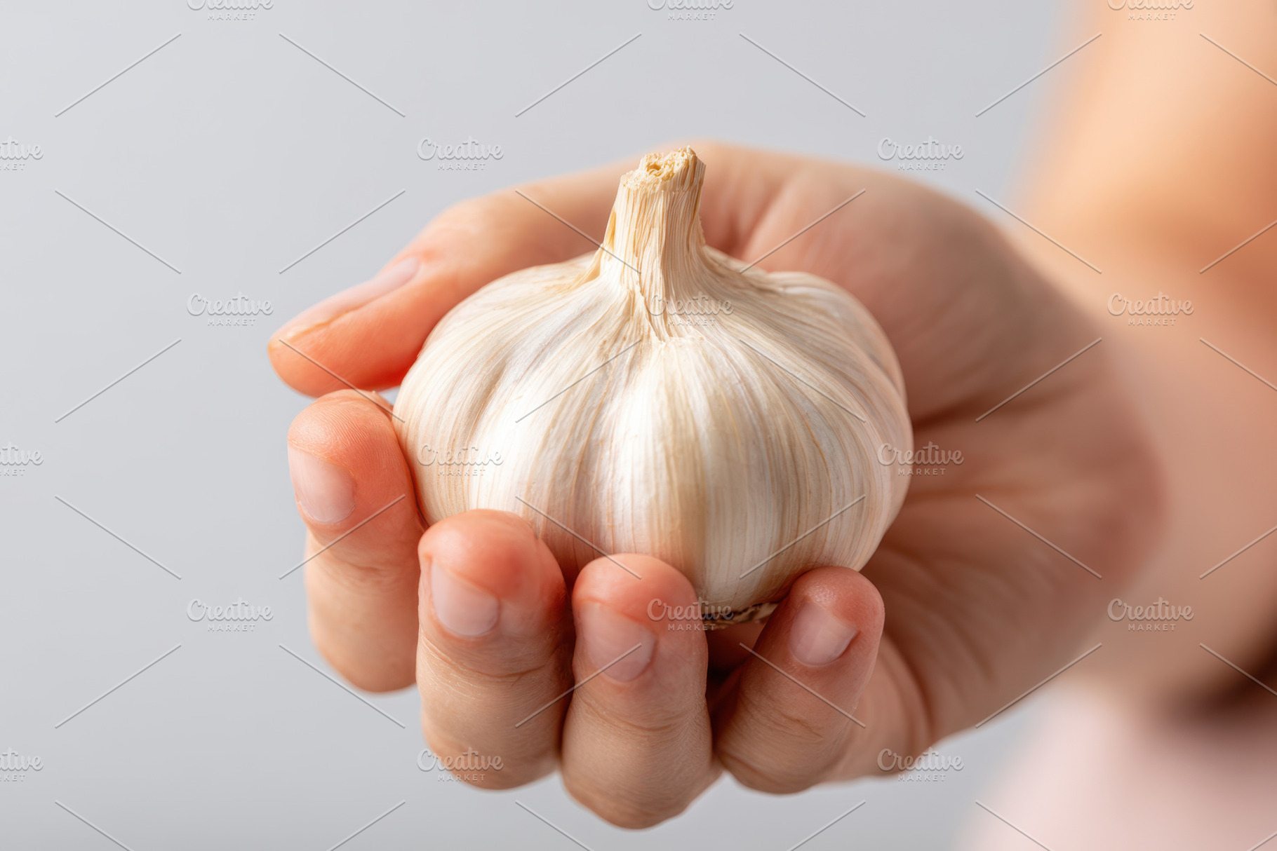 Fresh garlic bulb in hand, a Food & Drink Photo by AlyaAnd