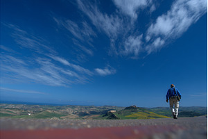 A man is walking on a road during a, a Nature Photo by ZinetroN