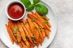 Sweet potato fries with ketchup and basil garnish, a Food & Drink Photo by Olena Rudo
