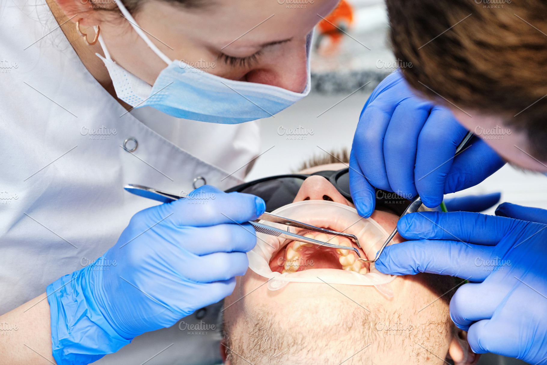 Close-up of a dental team performing a check-up with modern equipment and safet, a Health & Medical Photo by Rohan Photography