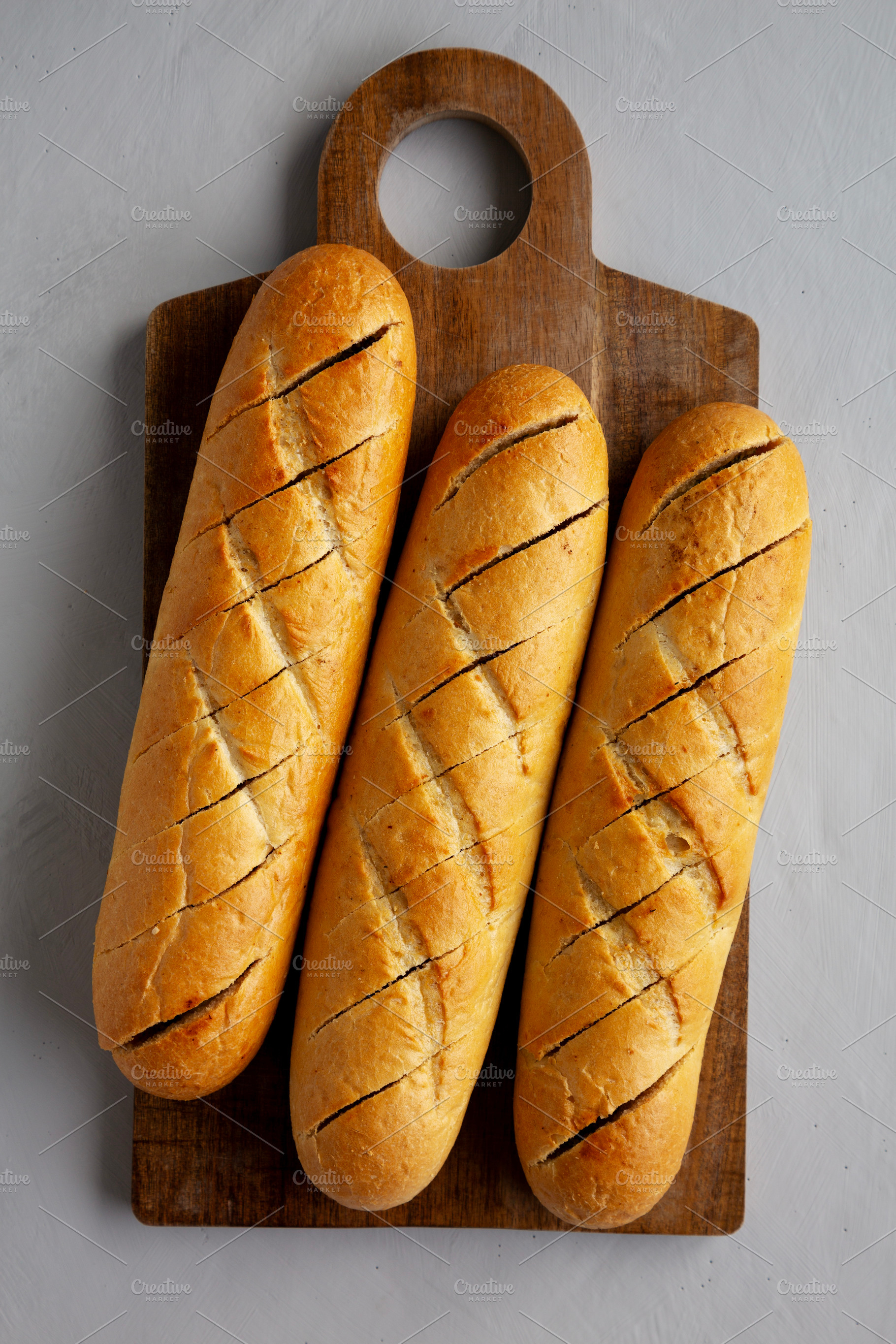 Homemade French Baguette with Garlic Filling on a wooden board,, a Food & Drink Photo by LiudmylaChuhunova