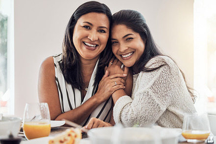 Family, love and mother with a woman and her daughter at home, eating food and enjoying time together. Love, dining room and lunch with a mature female sitting at a dinner table in their house, a Photo by Peopleimages.com