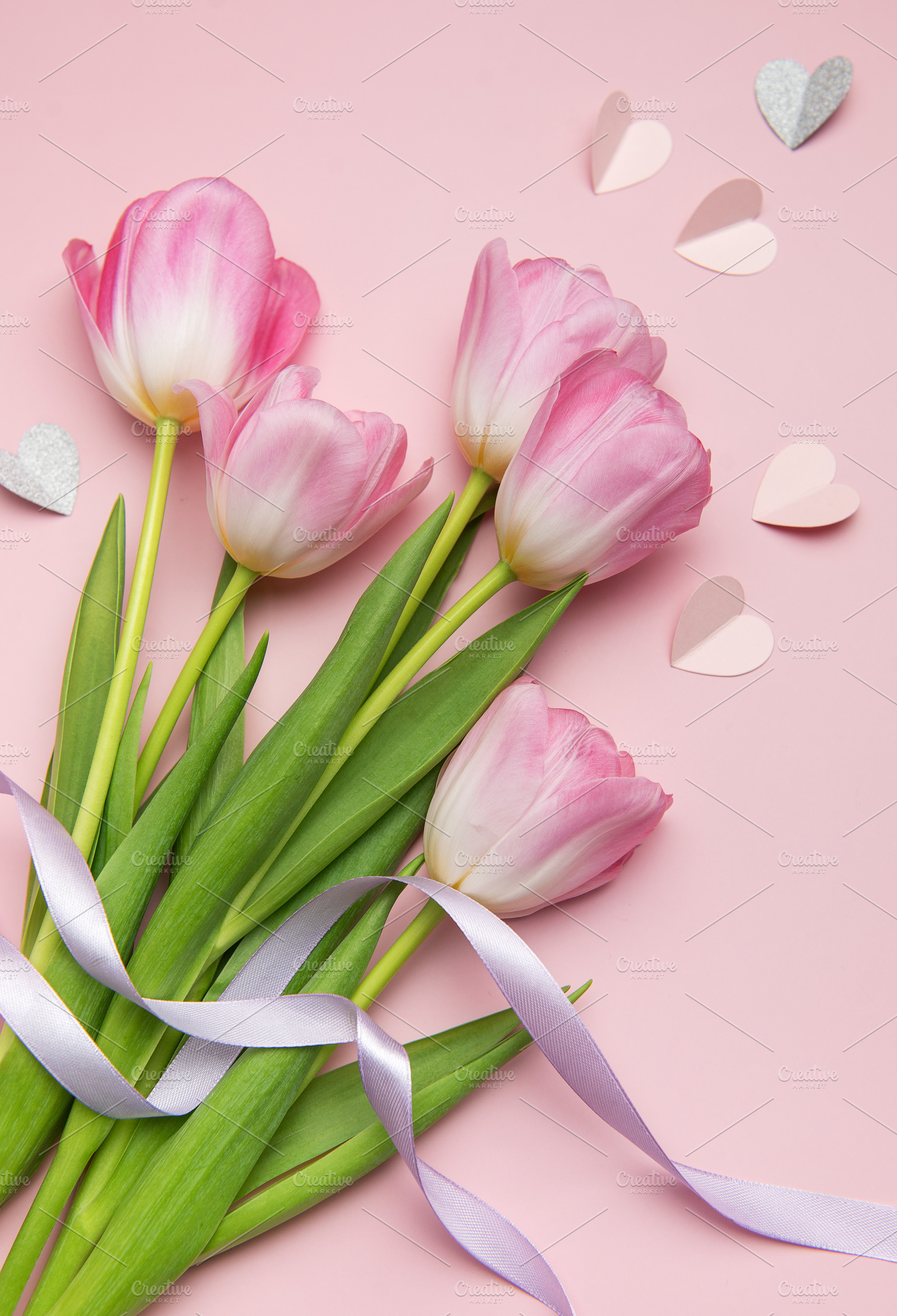 Pink tulips with purple ribbon and paper hearts creating lovely, a Holiday Photo by Olena Rudo